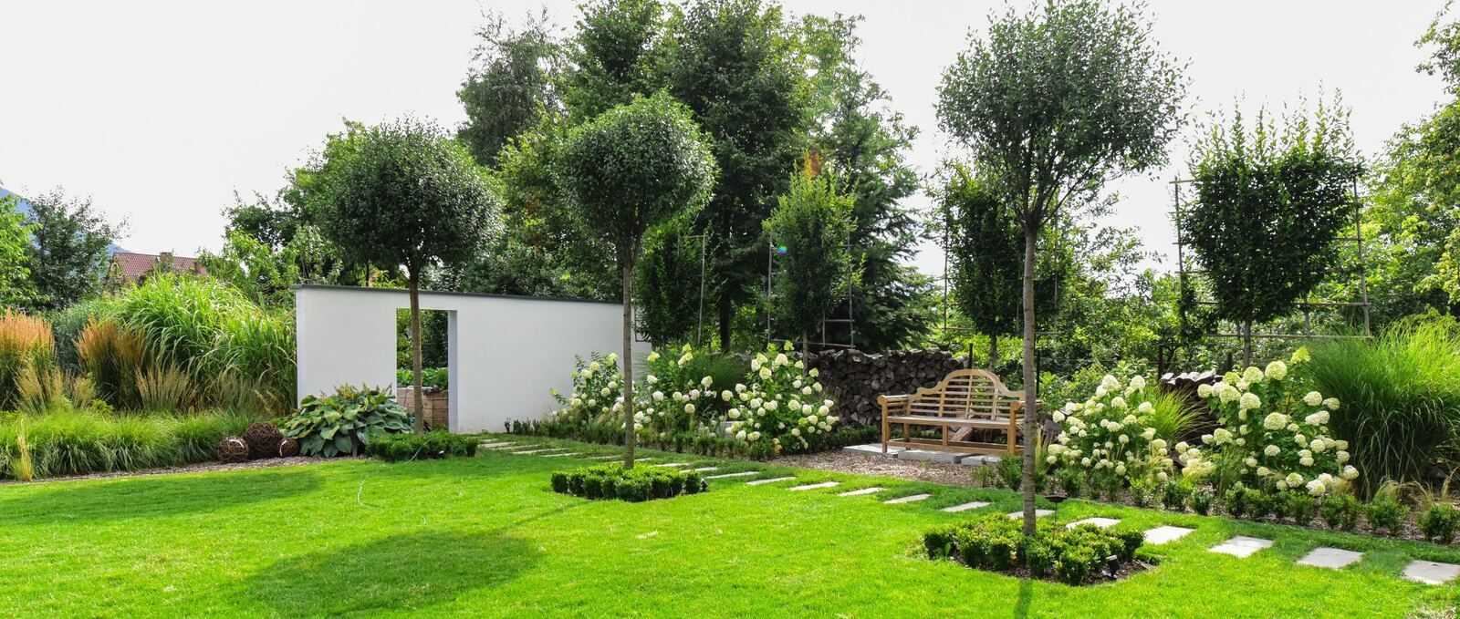 Aménagement paysager extérieur avec massifs et arbres taillés